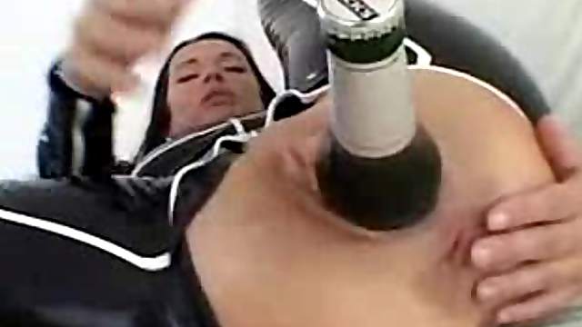 Bottle of beer inside the latex girl's ass