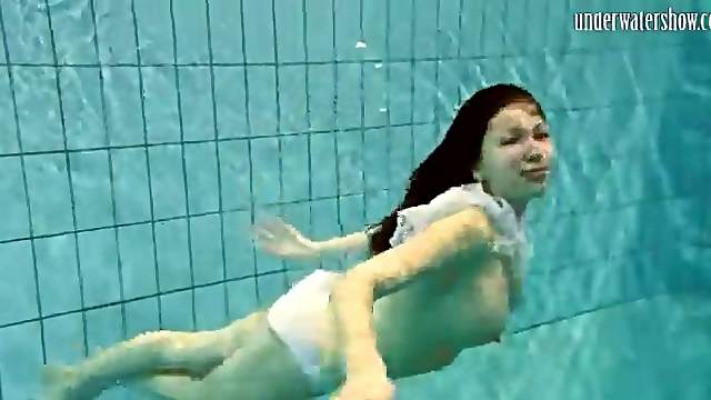 Girl in white panties swims in pool