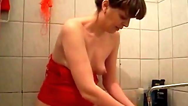 Brunette washes her pussy in the bathtub