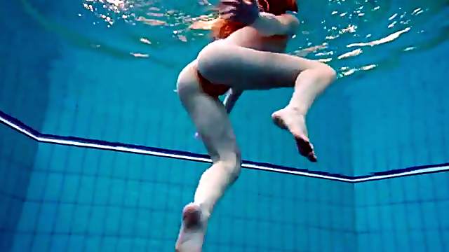 Swimming redhead strips underwater to tease us